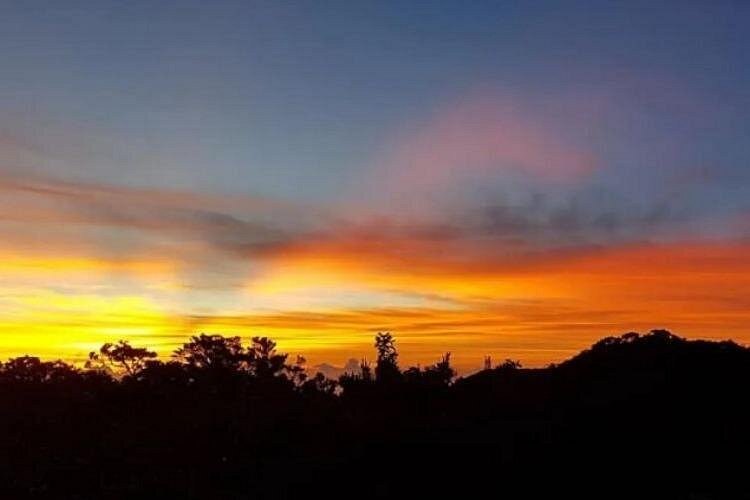Orange and pink cloud over the dark outline of the Blue Mountains at dusk